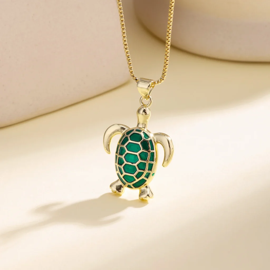 Collier à pendentif tortue vert et doré présenté sur un buste clair